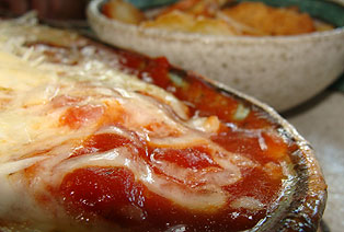 Muito queijo, molho de tomate e torradas para acompanhar